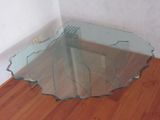 a glass table with a fork on it on a hard wood floor