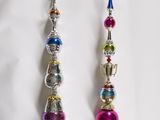 two silver and pink ornaments on a white background