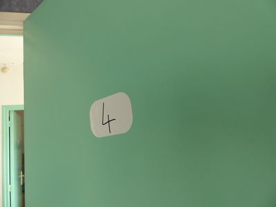 a clock on the wall in a room with a green wall