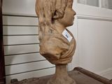 a bust of a young girl sitting on a table