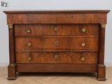 une commode ancienne posée sur un parquet dans une pièce