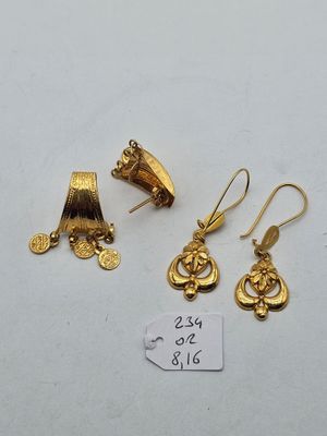 two pairs of gold earrings and a pair of gold earrings