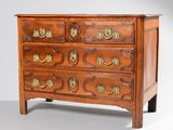 une commode ancienne dont les tiroirs sont ornés de ferrures en laiton