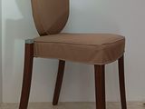 a chair that has a brown seat and a wooden frame