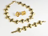 a gold necklace, bracelet and earring set on a white background