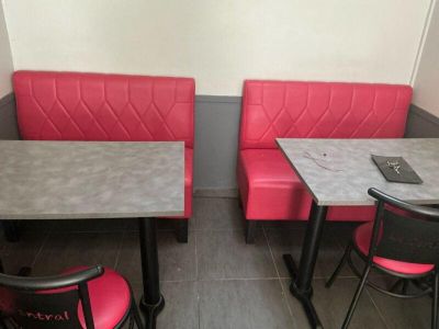 two tables and two chairs in the corner of a booth