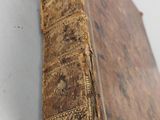 a close up of an old book on a white surface