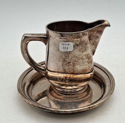un plateau en argent ancien sur lequel sont posés une tasse et une soucoupe