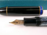 a fountain pen sitting next to a box on a table