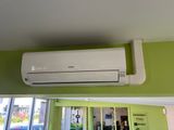 a white air conditioner on a green wall in a room