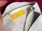 a hand holding a purse that has a tag on it