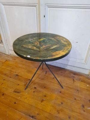a small table with a green top on a wooden floor