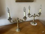trois bougies posées sur une table, avec un tableau accroché au mur
