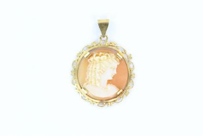 un gros plan sur un pendentif en or orné du portrait d'une femme