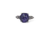 un gros plan d'une bague sertie d'un saphir violet et de diamants, sur fond blanc