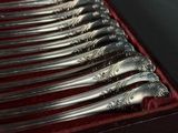 six cuillères en argent dans une boîte rouge posée sur une table