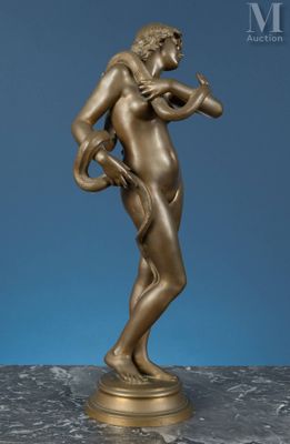 une statue antique en bronze représentant un homme tenant une balle, posée sur un socle en marbre