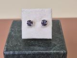 une paire de boucles d'oreilles en saphir bleu posées sur un bloc de marbre