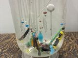 a glass vase with a bunch of beads in it on a table