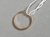 une photo d'une bague en or suspendue à un fil blanc