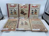 Six livres mettant en scène Mickey Mouse et d'autres personnages de dessins animés sont posés sur une table.