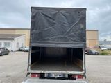 a black tarp on the back of a truck in a parking lot