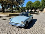 une petite voiture bleue garée dans une rue pavée