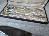 silverware in a case on a table next to a knife and spoon