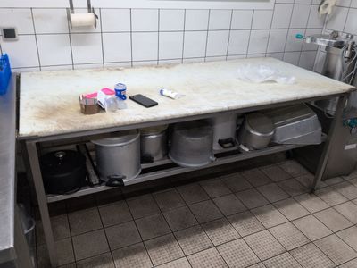 a sink in a public restroom with a lot of trash on the counter