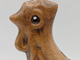 a small wooden bird that is sitting on a table