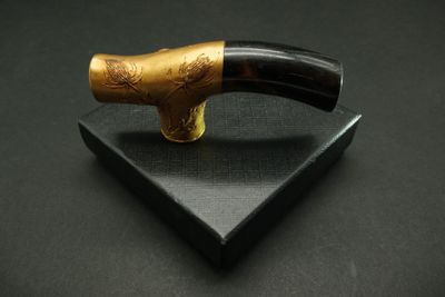 a pipe with a wooden handle on a black surface