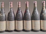 six bouteilles de vin sont alignées sur une table