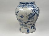 a blue and white vase sitting on a white surface