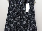 une chemise à motifs cachemire noir et blanc suspendue à un cintre