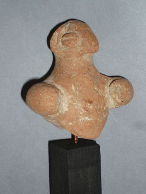 une image représentant une statue d'un homme posée sur un socle en bois