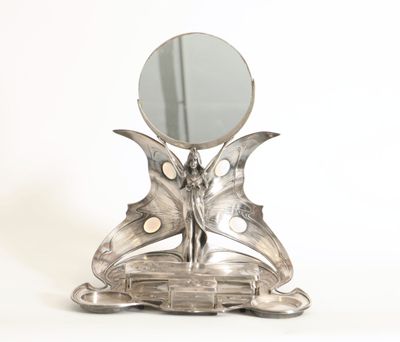 un miroir argenté en forme de papillon posé sur un socle, avec un miroir au centre