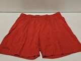un gros plan sur un short rouge posé sur une surface blanche