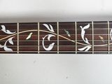 a close up of a guitar neck with leaves on it