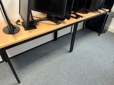 four computer monitors sitting on a desk in a room