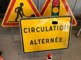 a yellow sign that says circulation alteranee next to some orange cones
