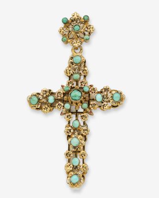 une croix en or ornée de pierres turquoise sur fond blanc