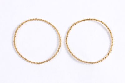 a pair of gold hoop earrings on a white background