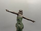 statue en bronze représentant une femme tenant une raquette de tennis, située au milieu d'un court de tennis