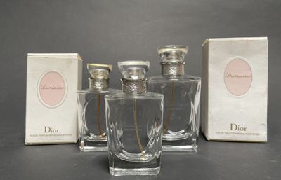 three bottles of perfume sitting on a table next to a box