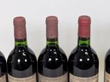 six bottles of wine are lined up in a row on a table