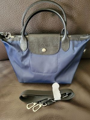 a blue and black purse with a keychain on a brown couch
