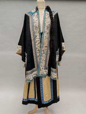 a woman ' s black and gold embroidered robe with blue trim