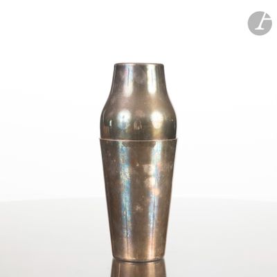 un vase en argent posé sur une table, sur fond blanc