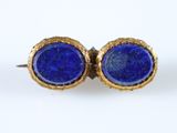 un gros plan sur une paire de boucles d'oreilles en pierre bleue posées sur une surface blanche