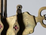 two keys attached to a metal object with a cross on it
